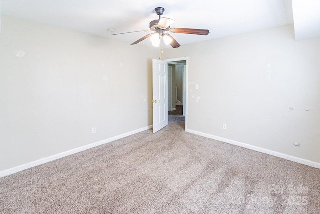 spare room with ceiling fan, baseboards, and light colored carpet