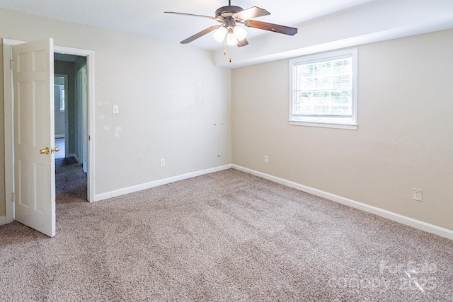 carpeted empty room with ceiling fan and baseboards