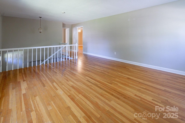 spare room featuring wood finished floors and baseboards