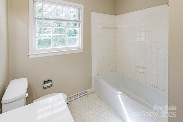 bathroom featuring bathing tub / shower combination, tile patterned flooring, toilet, and baseboards