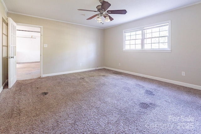 unfurnished room with carpet floors, baseboards, ornamental molding, and a ceiling fan