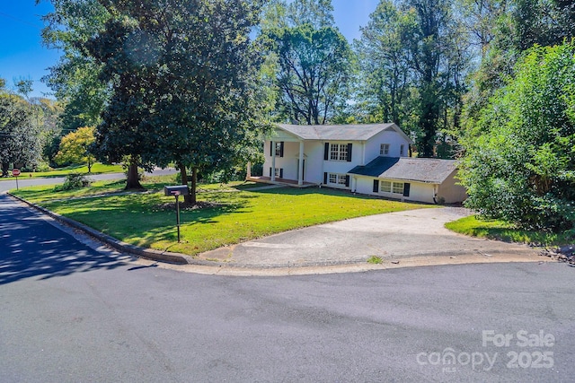 bi-level home featuring aphalt driveway and a front yard