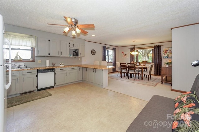 kitchen with kitchen peninsula, white dishwasher, decorative light fixtures, a textured ceiling, and ceiling fan