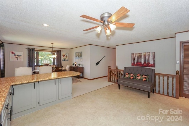 kitchen featuring a textured ceiling, gray cabinetry, ceiling fan, and pendant lighting