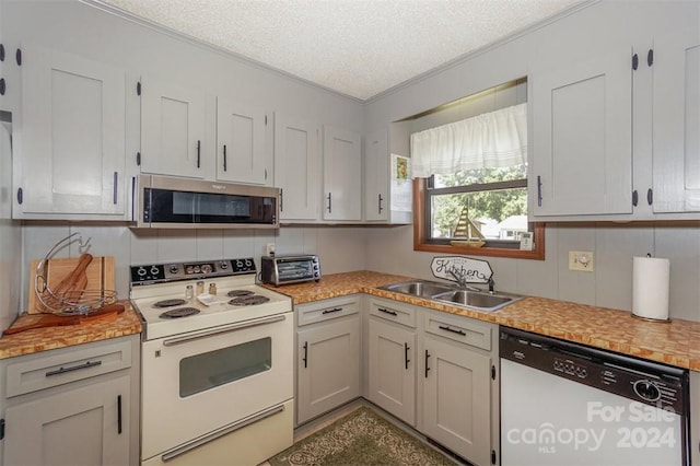 kitchen with dishwashing machine, sink, electric range, white cabinetry, and a textured ceiling