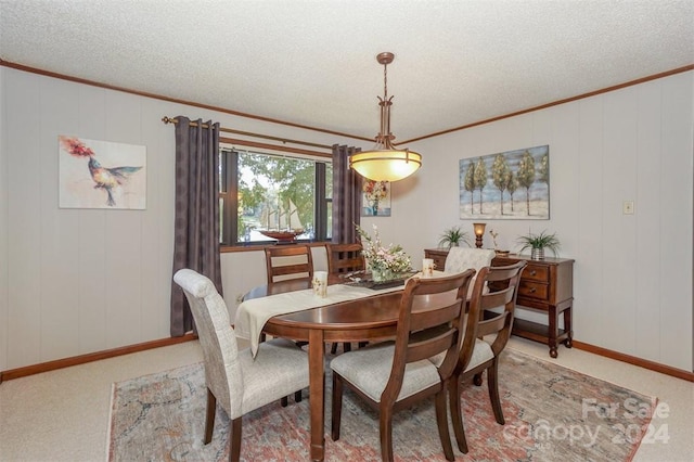 carpeted dining room featuring a textured ceiling and ornamental molding