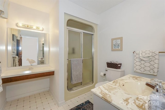 bathroom with vanity, toilet, and a shower with door