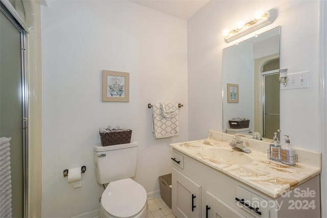 bathroom with a shower with door, vanity, and toilet