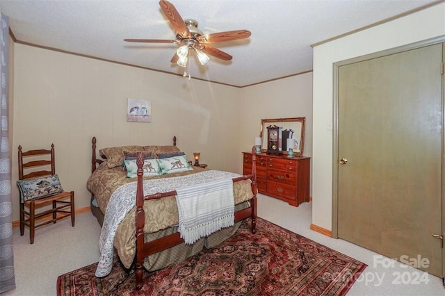 carpeted bedroom featuring crown molding, a textured ceiling, a closet, and ceiling fan