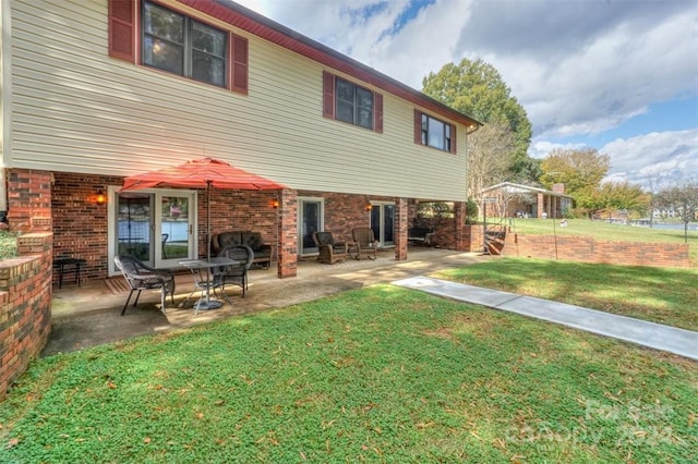 back of property featuring a patio and a yard