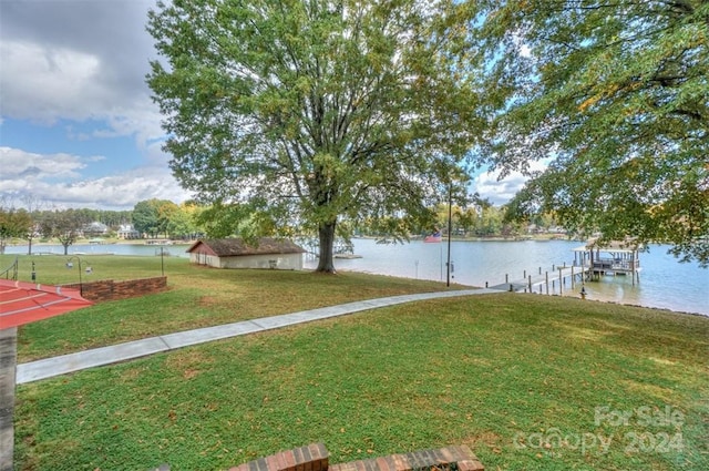 view of yard featuring a water view and a boat dock