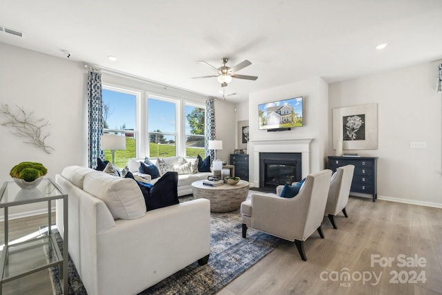 living room featuring ceiling fan and light hardwood / wood-style flooring