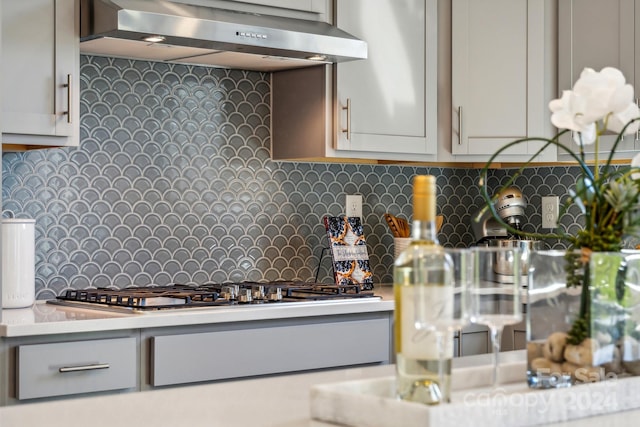 kitchen with ventilation hood and decorative backsplash