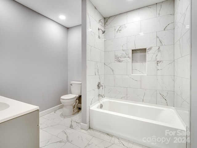 full bathroom featuring toilet, tiled shower / bath, and vanity