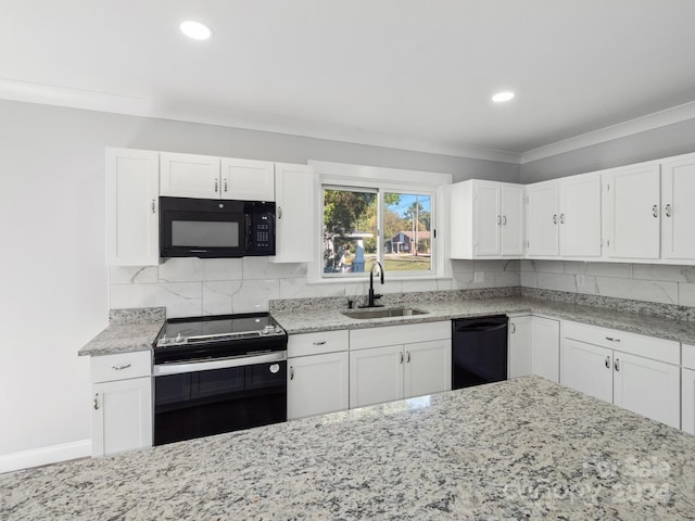 kitchen featuring decorative backsplash, white cabinets, black appliances, and sink