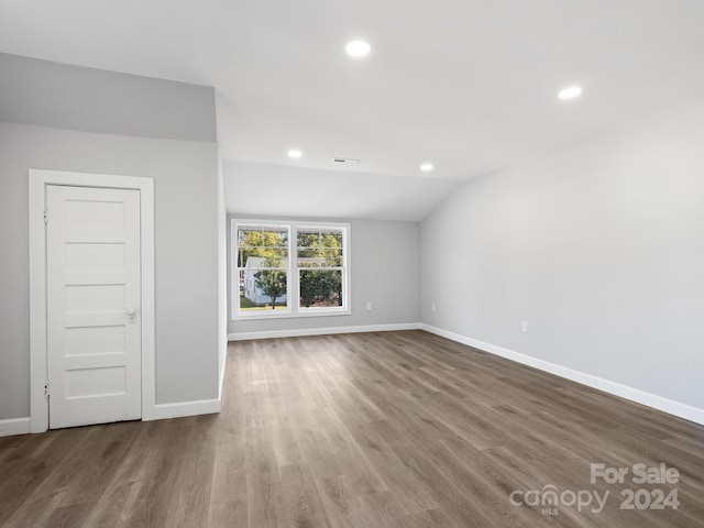 unfurnished room featuring vaulted ceiling and hardwood / wood-style flooring