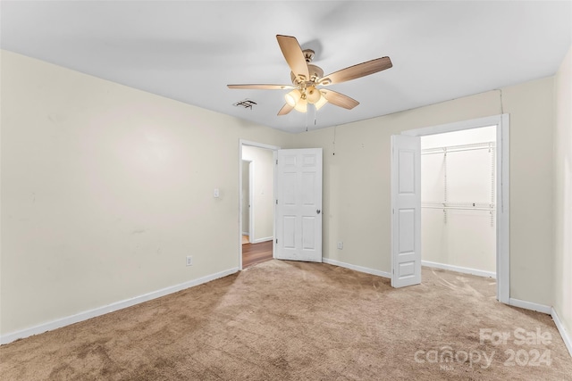 unfurnished bedroom featuring ceiling fan, a closet, and light colored carpet