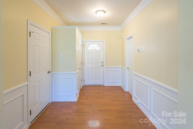 entryway with hardwood / wood-style floors and crown molding