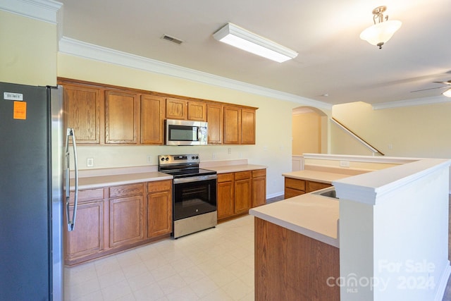 kitchen featuring appliances with stainless steel finishes, ceiling fan, crown molding, and a kitchen island