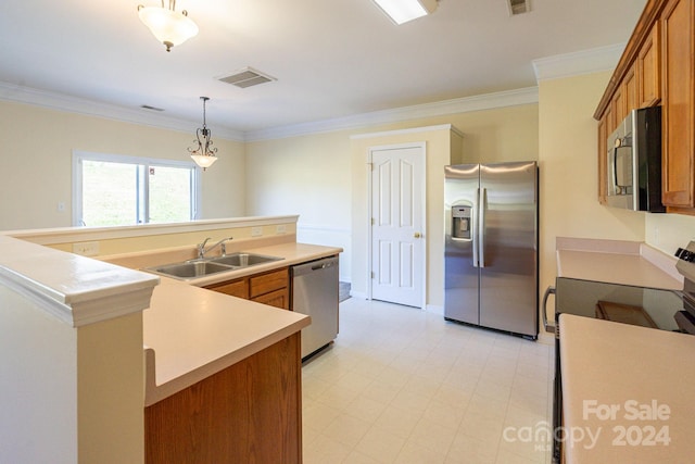 kitchen with pendant lighting, appliances with stainless steel finishes, sink, and crown molding