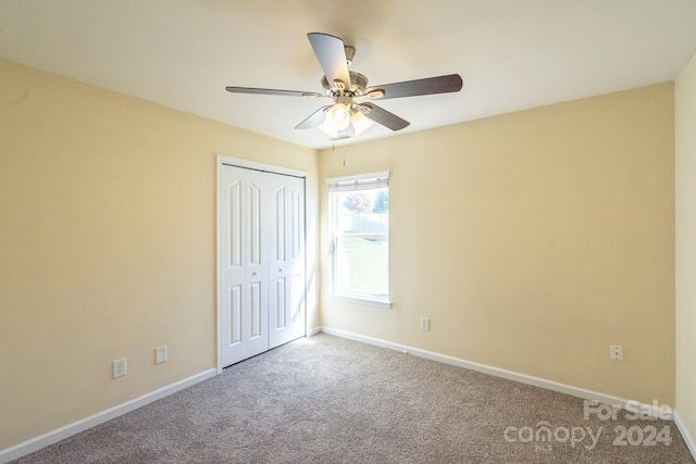 unfurnished bedroom with a closet, ceiling fan, and carpet floors