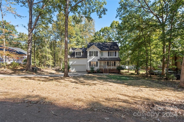 view of front property with a porch and a garage