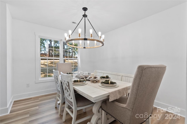 dining room with light hardwood / wood-style flooring and a chandelier