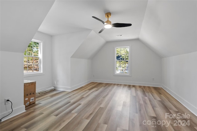 bonus room with a wealth of natural light, lofted ceiling, and light hardwood / wood-style flooring