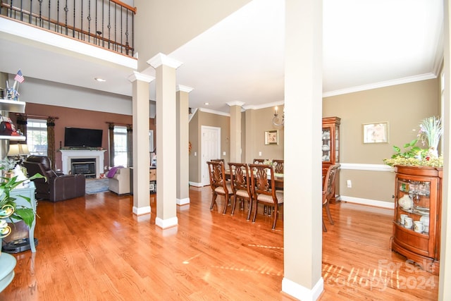 interior space featuring ornamental molding, decorative columns, and light hardwood / wood-style flooring