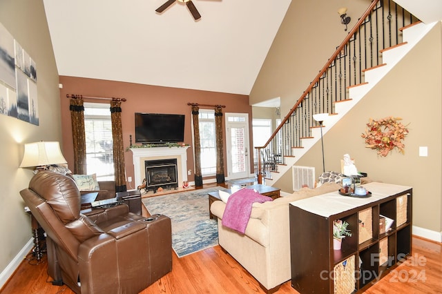 living room with wood-type flooring and high vaulted ceiling