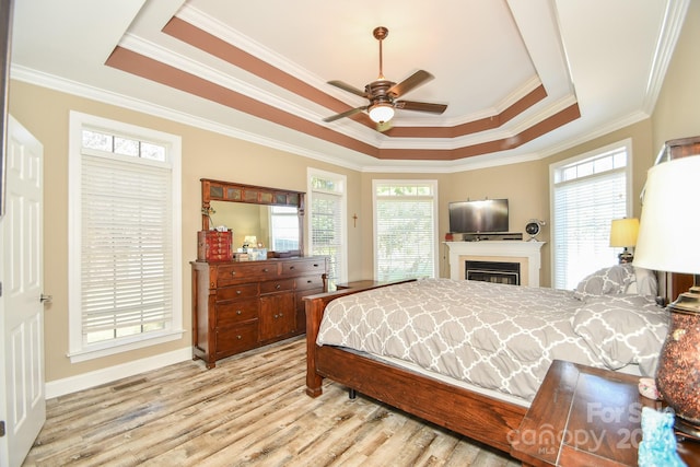 bedroom with multiple windows, ceiling fan, light wood-type flooring, and crown molding