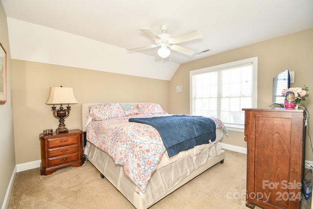 bedroom with lofted ceiling, light colored carpet, and ceiling fan