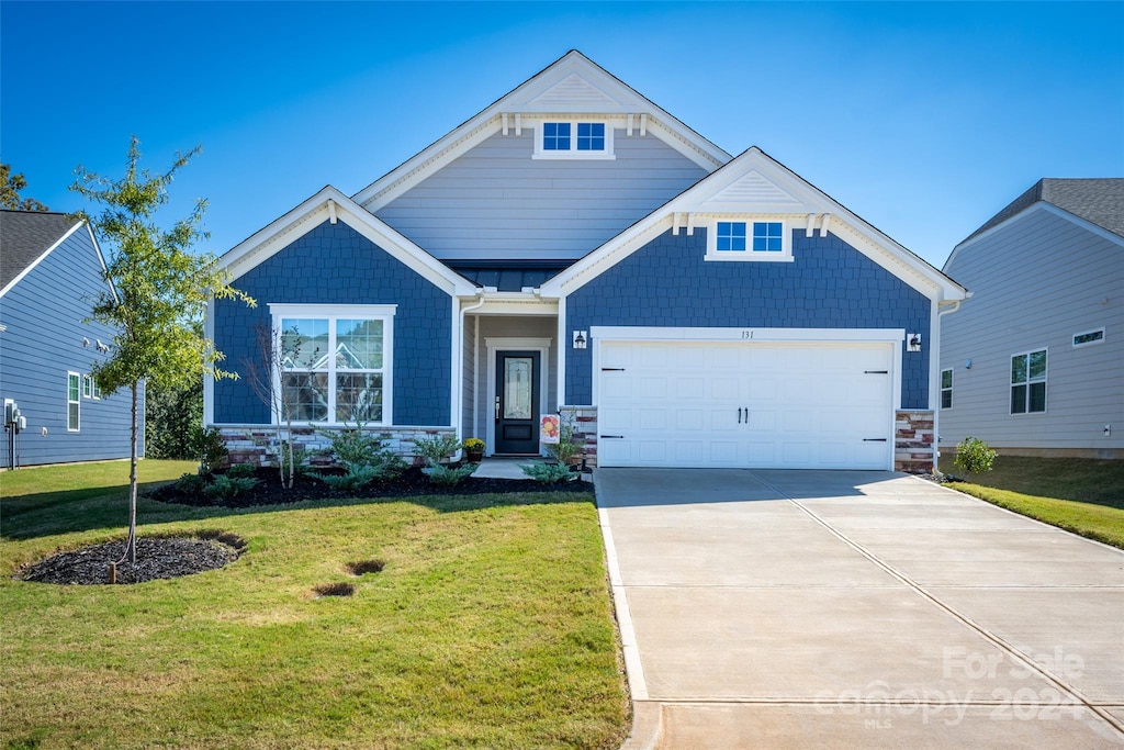 craftsman-style home featuring a front yard and a garage