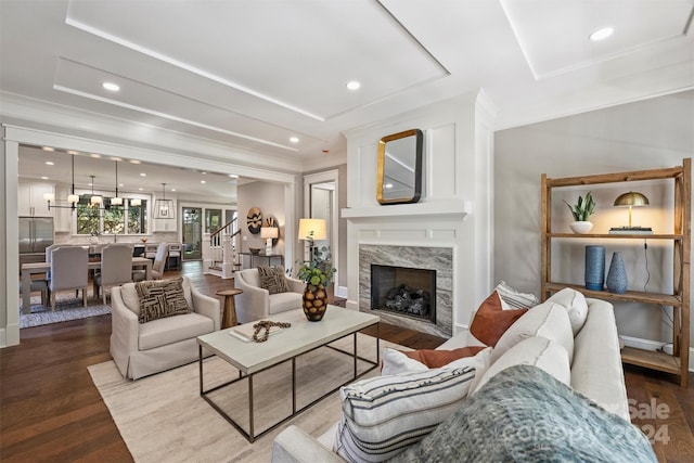 living room with hardwood / wood-style flooring, crown molding, and a premium fireplace