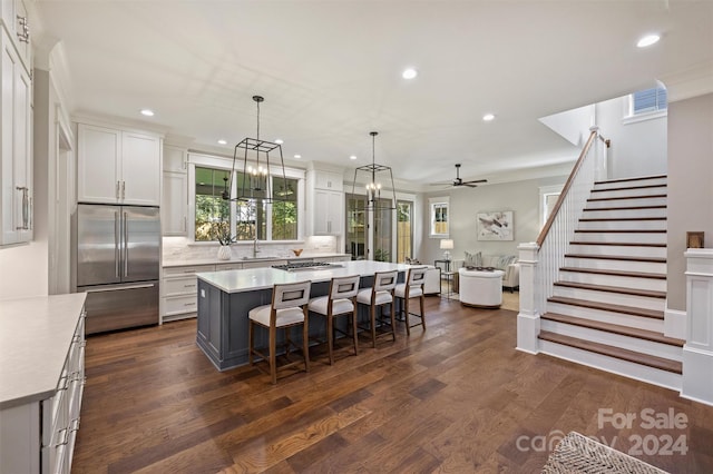 kitchen featuring dark hardwood / wood-style flooring, high end refrigerator, a center island, and decorative light fixtures