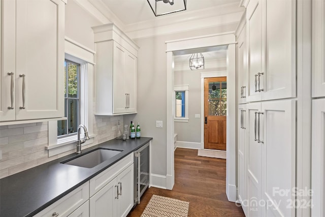 kitchen with white cabinets, decorative backsplash, wine cooler, and sink