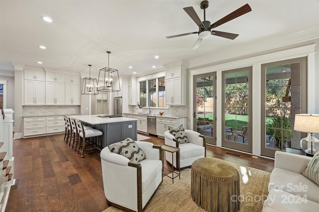 living room with crown molding, sink, ceiling fan with notable chandelier, and dark hardwood / wood-style floors