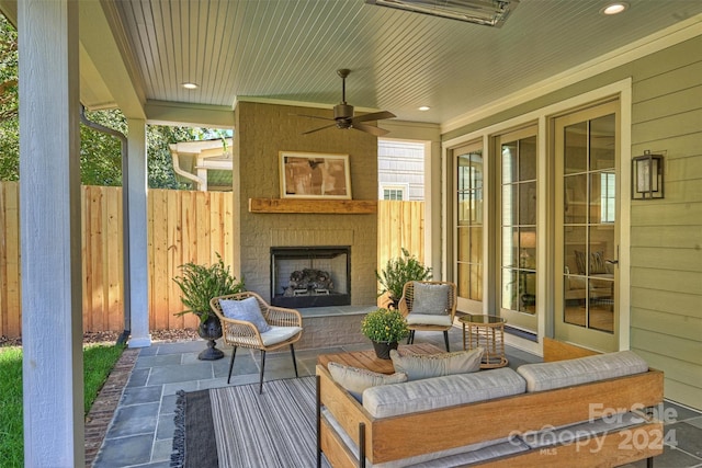 view of patio with a fireplace and ceiling fan