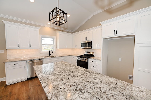 kitchen with lofted ceiling, white cabinets, hanging light fixtures, sink, and appliances with stainless steel finishes