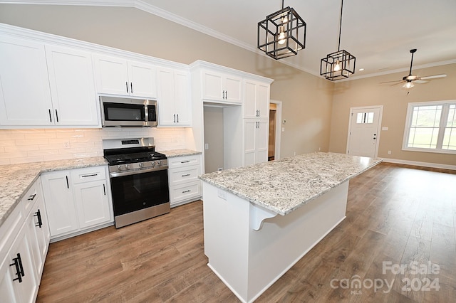 kitchen with ceiling fan, appliances with stainless steel finishes, pendant lighting, white cabinets, and light wood-type flooring