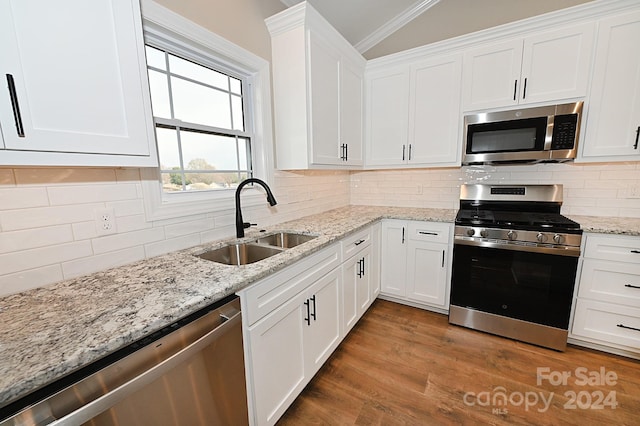 kitchen featuring appliances with stainless steel finishes, crown molding, sink, hardwood / wood-style flooring, and white cabinets