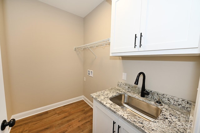 laundry room with cabinets, sink, washer hookup, and hardwood / wood-style flooring