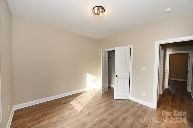 unfurnished bedroom featuring wood-type flooring and a closet