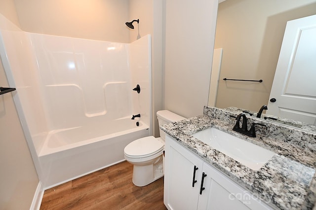 full bathroom featuring toilet, hardwood / wood-style floors, vanity, and washtub / shower combination