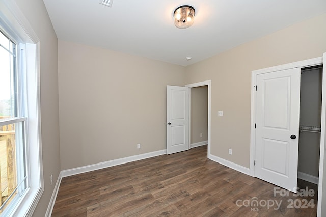 unfurnished bedroom featuring dark hardwood / wood-style floors and a closet