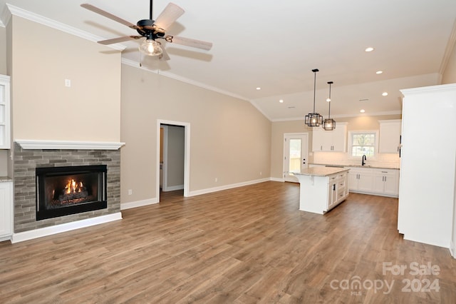 kitchen featuring white cabinets, decorative light fixtures, a kitchen island, and light hardwood / wood-style floors