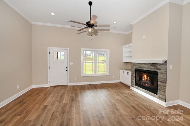 unfurnished living room featuring light wood-type flooring, a brick fireplace, ceiling fan, and ornamental molding