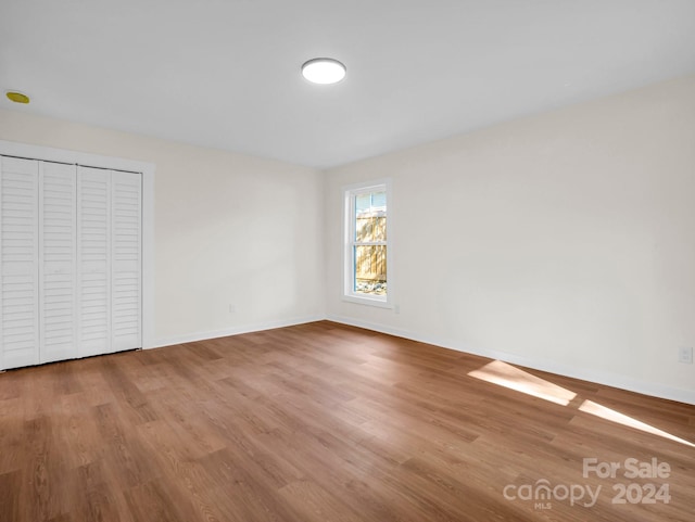 unfurnished bedroom with a closet and wood-type flooring