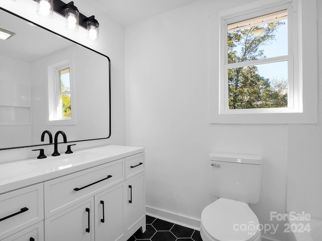 bathroom featuring vanity, toilet, and a healthy amount of sunlight