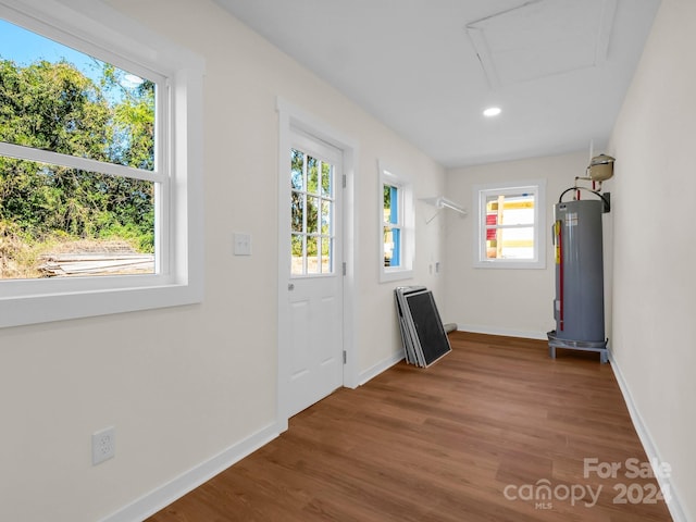 doorway with water heater and hardwood / wood-style floors